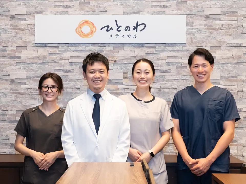 院長とスタッフが受付前に並んでいる写真