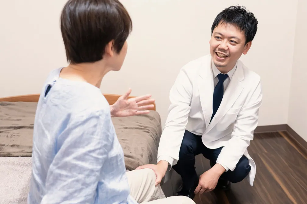 患者様の手を取って向き合う医師