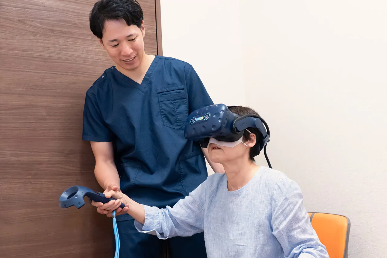 VRリハビリ機器を装着した患者様に付き添うスタッフ