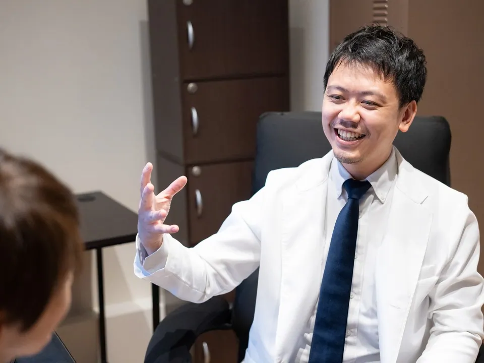 診察室で患者様に説明している院長の写真
