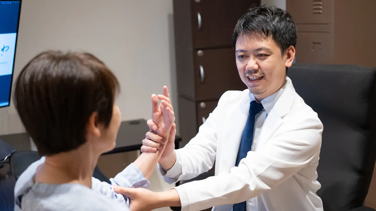 医師が患者の腕の動きを確認している様子